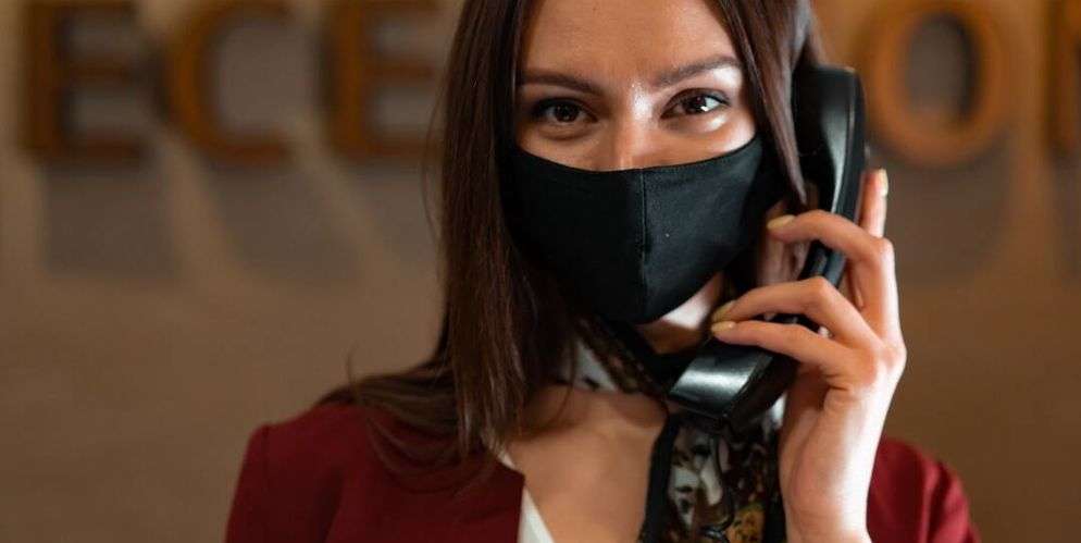receptionniste masquée au téléphone