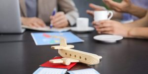 Wooden airplane with passports and tickets on table in travel agency